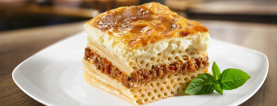 A square of pastitsio, layered pasta and seasoned beef topped with browned cream sauce