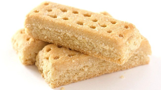 Scottish shortbread fingers stacked on a white plate